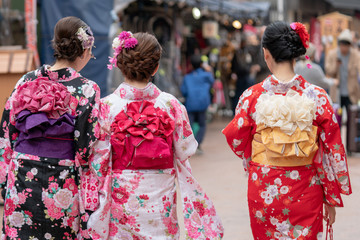 Young girl wearing Japanese kimono standing in front of Sensoji Temple in Tokyo, Japan. Kimono is a...