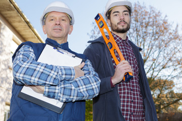 smiling builders in hardhats outdoors