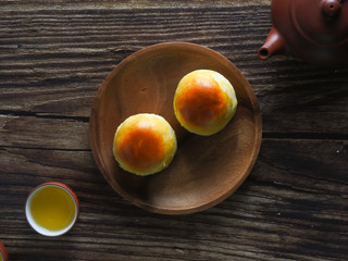 Mid-autumn festival is a traditional festival of East Asian culture and folk. Top view of yolk pastry and Oolong tea on wooden background. With copy space.  Flat lay.  Taiwan food.