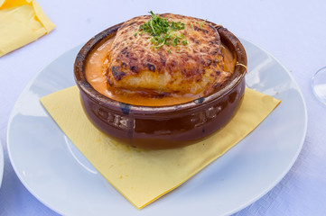 Portion of lasagna bolognese in a terracotta ramekin