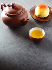 Mid-autumn festival is a traditional festival of East Asian culture and folk. High angle view of yolk pastry and Oolong tea on black background. With copy space.  Flat lay.  Taiwan food.