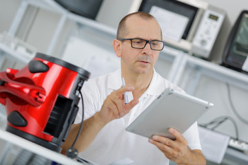 technician checks his table to fix a vaccum cleanner