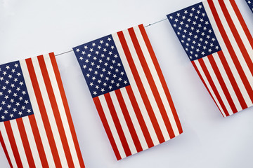 Garland of american flags of rectangular shape close-up on light background, banner design. Fest, city street holiday, celebration concept