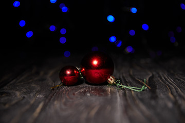 shiny red christmas balls on wooden table with blue sparkling background