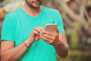 Modern man using cellphone outdoors.