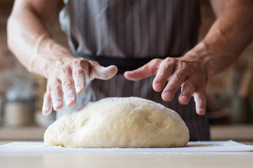 food cooking concept. chef preparing homemade bread or puff pastry. man hands ready to knead dough.