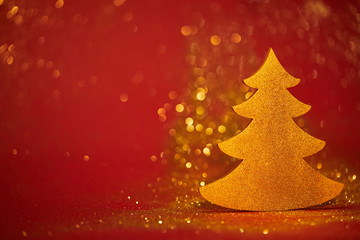 golden glittering decorative christmas tree on red background
