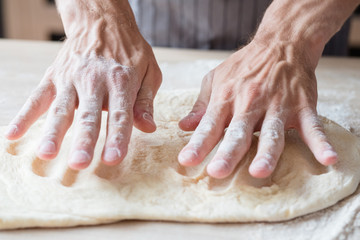 bakery and homemade puff pastry. food preparing and cooking skills concept. man hands kneading dough.