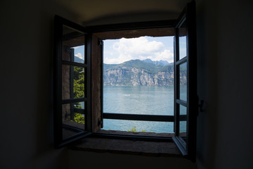 Window on Lake Garda (Italy), a holiday area appreciated by many European tourists. Lake panorama seen through a window.