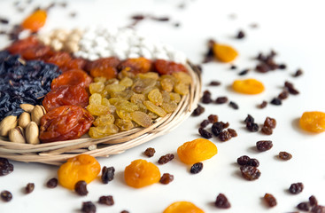 dried fruits, raisins, dried apricots, nuts, dried grapes, dried peaches on white background