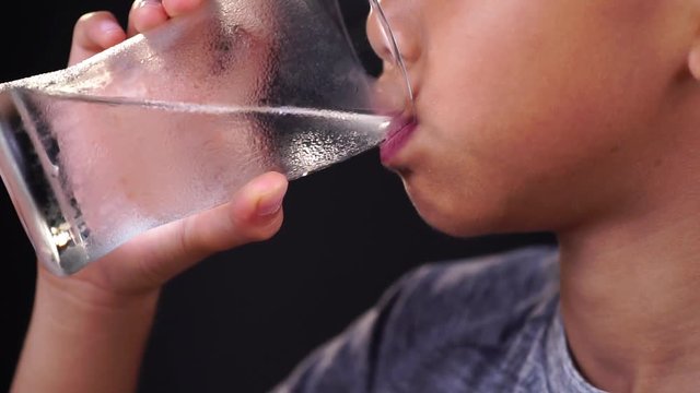 Slow motion of young Asian boy drinking water