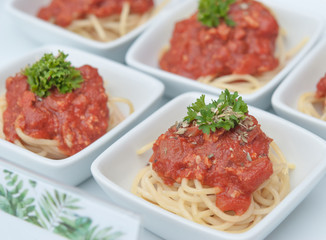 Beautifully decorated catering spaghetti topped tomato sauce in the white bowl