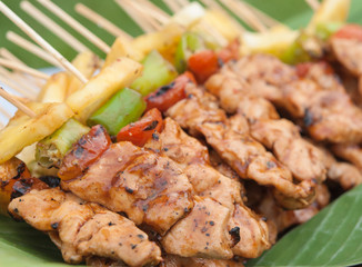 Beautifully decorated catering banquet buffet. Grilled chicken meat skewers slices with pineapple, chili and tomato.