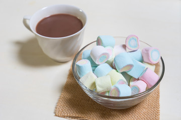 Marshmallows in glass cup on hot coco with white cup,