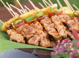 Beautifully decorated catering banquet buffet. Grilled chicken meat skewers slices with pineapple, chili and tomato.