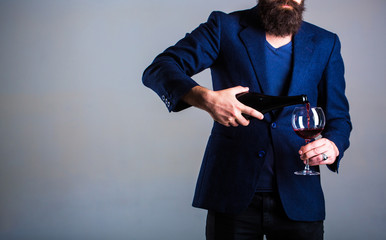 Bottle, red wine glass. Beard man, bearded, sommelier, tasting. Pouring red wine from bottle into the wineglass. Waiter pouring red wine in a glas. Sommelier man, degustator, winery, male winemaker.