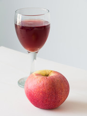 Red apple on wine in glass background,