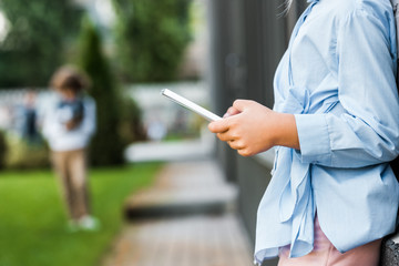 Obraz na płótnie Canvas cropped shot of child using digital tablet outside