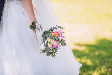 bride and groom holding wedding bouquet. Focus on flowers. Place for text.