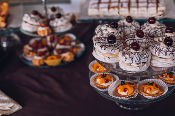 Delicious wedding reception candy bar dessert table. A lot of alcohol and glasses. Coktails and sweets. Wedding party table.