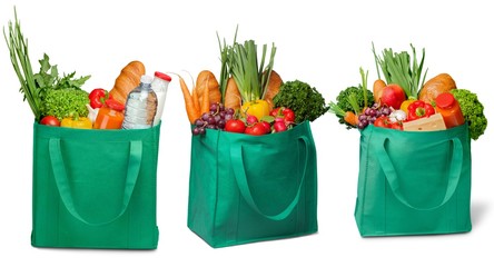 Shopping bags with groceries on white