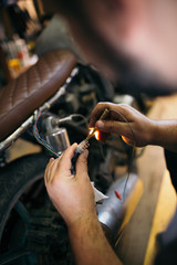 Fototapeta premium Close up shot of experienced man working in custom made motorcycle workshop.