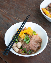 Noodles soup with beef Thai food style name Boat Noodles on wooden table