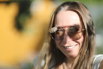 Young woman with long hair in sunglasses with a mirror surface of lenses