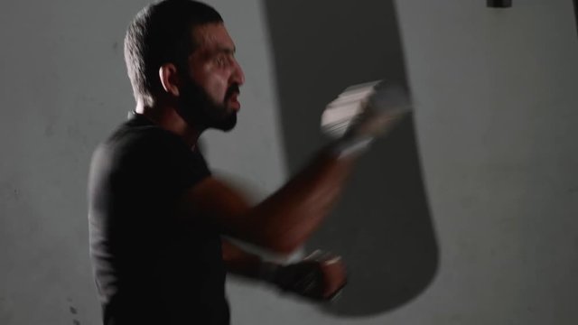 Male bearded boxer exercising shadow boxing.