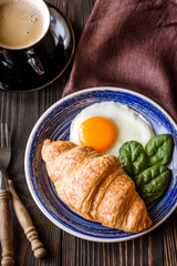 Fried egg with croissant and a cup of coffee