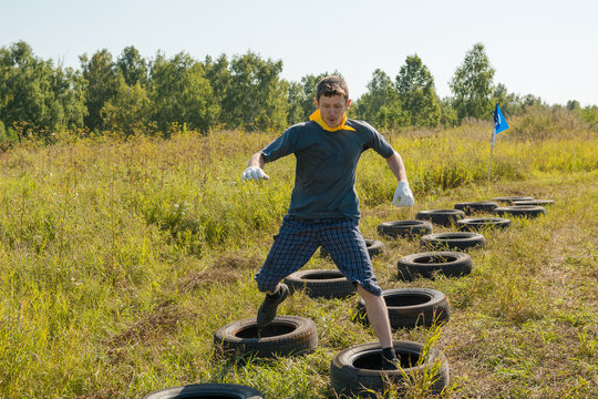 A man is jumping over the tires. Competitions with automobile tires.