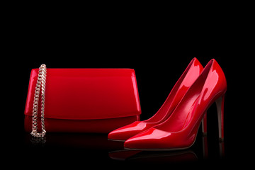 Elegant red shoes red handbag on a black background.
