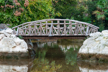 A wooden bridge in a pond at a park