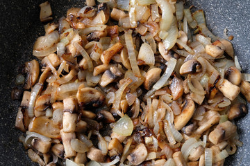 fried mushrooms with onions in a frying pan