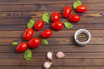 Various vegetarian Ingredients (spinach, tomatoes and spices) on a dark wooden table, top view. Healthy eating, vegan nutrition concept.