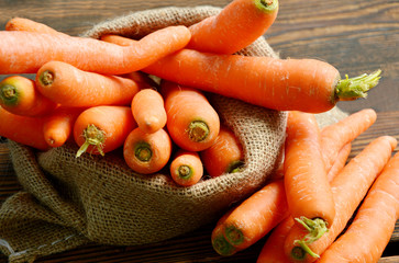 Carrots in sack bag on wooden floor.
Carrots provide a number of nutrients other than beta-carotene. They are rich in fiber.