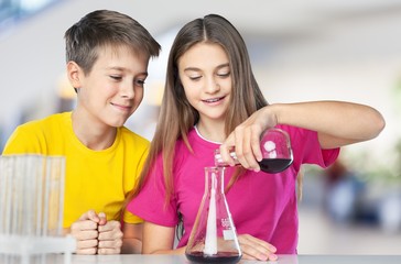 Children doing chemical experiment with glass tubes