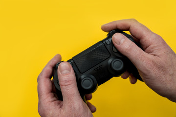 Man playing video game holding gaming controller in hands © Tom Eversley