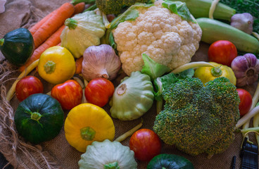 Different vegetables, small patissons, along with other vegetables, cauliflower, broccoli, garlic, cucumbers grown on an eco-farm