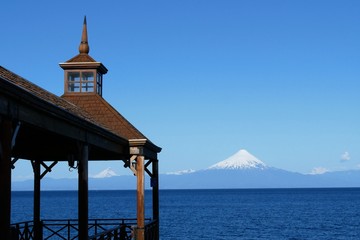 Fototapeta na wymiar Snow covered Volcano Osorno behind the blue Lake Llanquihue in Puerto Varas in Patagonia Chile