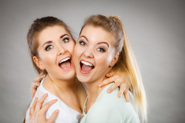 Two happy friends women hugging