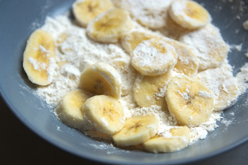 Sliced plantain with flour on a gray plate