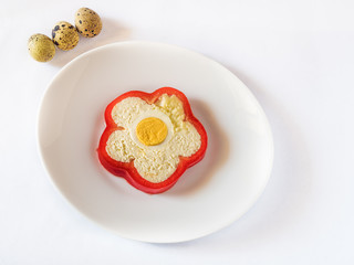 Slice of pepper stuffed with sheep cheese and quail eggs on white plate and white background. Quail eggs, space for text, cheese