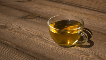 cup of herbal tea with chamomile flowers on a wooden table