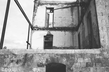 Walls and facade of an old ruined abandoned building. Black and white photo