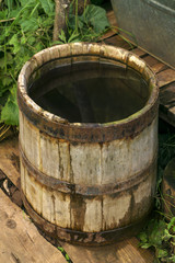 ancient wooden bucket with water stands in the backyard outdoor