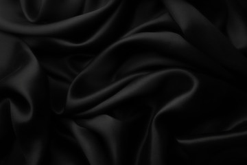 Fototapeta premium Elegancki czarny satynowy jedwab z falami, abstrakcyjne tło.