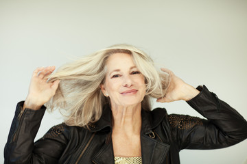 stunning beautiful and self confident best aged woman with grey hair smiling into camera, portrait...