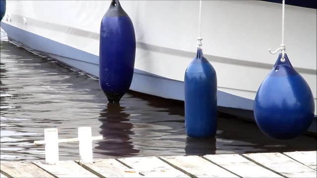 blue fender, boat at a wooden pier

