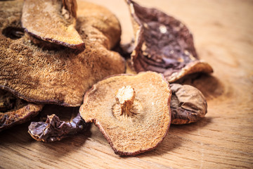 Dry mushrooms on wooden rustic table.